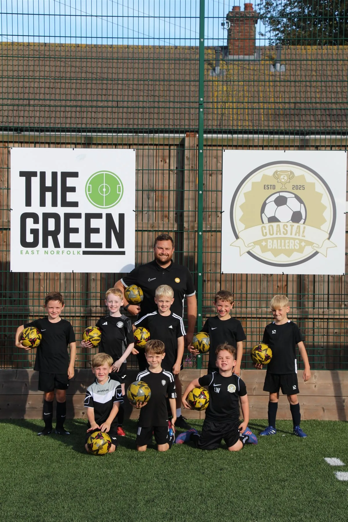 Young Coastal Ballers football players with their coach at The Green